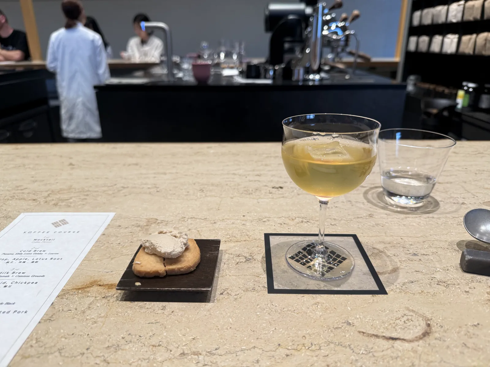 コースで供される一杯。奥にはバリスタと、ずらりと並んだ焙煎豆の棚が見える